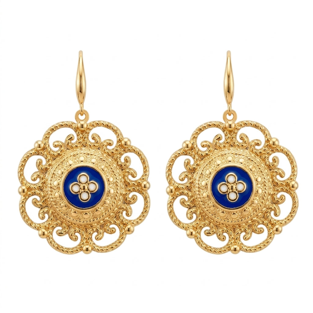 Paire de boucles d'oreilles pendantes dorées de style byzantin, ornées d'un médaillon en émail bleu cobalt portant un motif floral en nacre blanche.